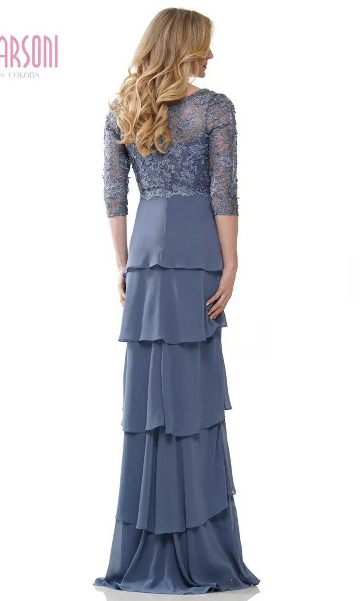 A woman with long blonde hair is seen from the back against a white background, wearing the Marsoni MV1244 long formal dress, which features a lace embroidered bodice, blue chiffon tiered column skirt, and three-quarter sleeves.